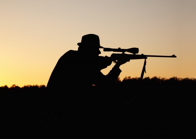 Hunter silhouetted at sunset