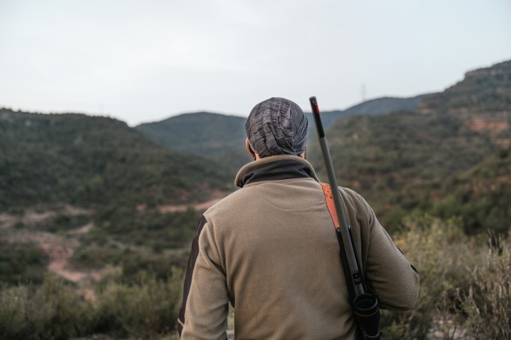 Hunter scanning savanna at sunrise